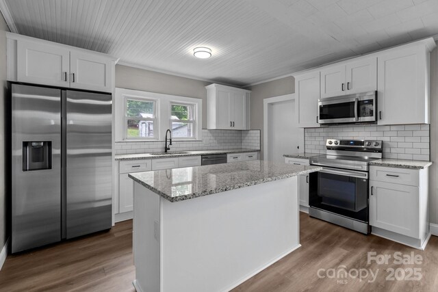 1406 Upper Enochville Rd, Kannapolis, NC 28081 - kitchen featuring stainless steel appliances, a sink, dark wood-style flooring, white cabinets, and a center island