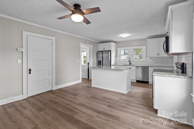 1406 Upper Enochville Rd, Kannapolis, NC 28081 - kitchen featuring stainless steel appliances, ornamental molding, a kitchen island, wood finished floors, and tasteful backsplash