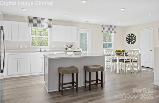 10124 Florentine Way, Charlotte, NC 28214 - kitchen featuring white cabinetry, a breakfast bar area, a kitchen island, and recessed lighting