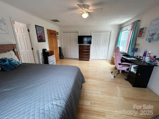 4574 Ivy Run Ln, Denver, NC 28037 - bedroom featuring multiple closets, light wood-style floors, an office area, a ceiling fan, and a textured ceiling