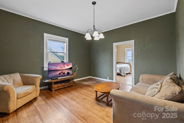 61 First St, Marion, NC 28752 - living room featuring ornamental molding, healthy amount of natural light, a chandelier, light wood-style floors, and baseboards