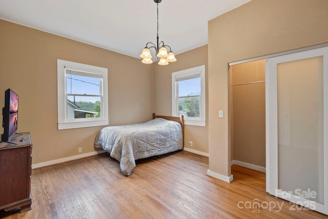 61 First St, Marion, NC 28752 - bedroom featuring a chandelier, light wood-style flooring, and baseboards