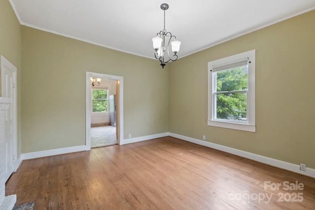 61 First St, Marion, NC 28752 - empty room with a chandelier, ornamental molding, light wood-style flooring, and baseboards