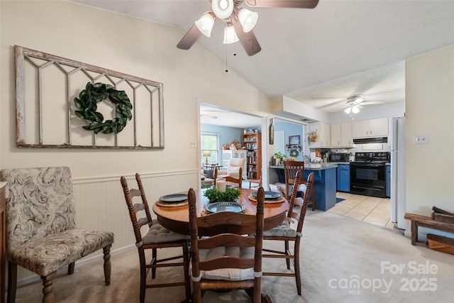 16 Fieldstone Ct, Arden, NC 28704 - dining area with a ceiling fan, light colored carpet, vaulted ceiling, and a wainscoted wall