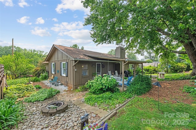 16 Fieldstone Ct, Arden, NC 28704 - rear view of property featuring board and batten siding, a chimney, a patio, and an outdoor fire pit