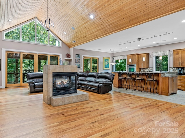 105 Blackberry Ln, Fairview, NC 28730 - living area featuring light wood-type flooring, a tiled fireplace, a chandelier, and high vaulted ceiling