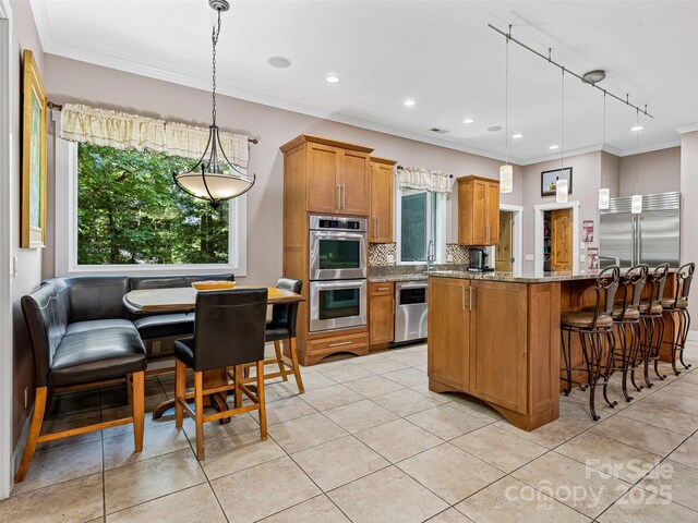 105 Blackberry Ln, Fairview, NC 28730 - kitchen featuring appliances with stainless steel finishes, crown molding, tasteful backsplash, stone countertops, and brown cabinetry