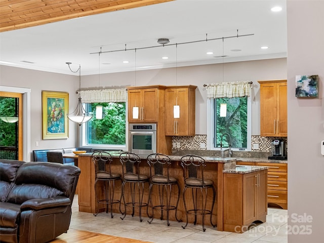 105 Blackberry Ln, Fairview, NC 28730 - kitchen with oven, brown cabinets, a kitchen bar, and crown molding