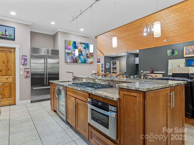105 Blackberry Ln, Fairview, NC 28730 - kitchen featuring appliances with stainless steel finishes, stone countertops, brown cabinetry, decorative light fixtures, and light tile patterned floors