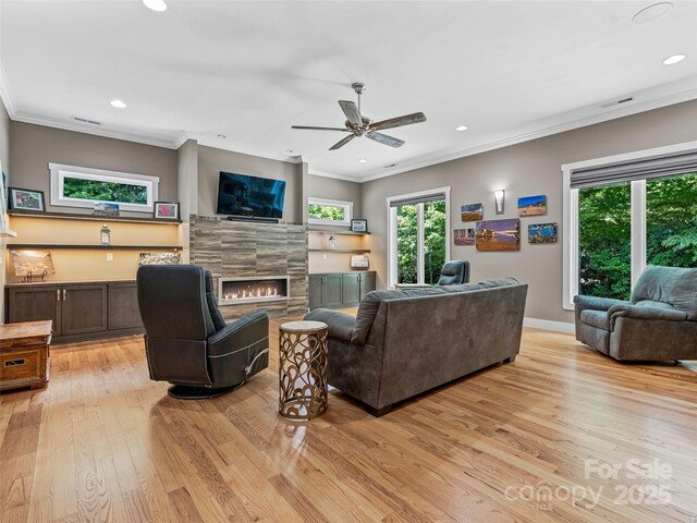 105 Blackberry Ln, Fairview, NC 28730 - living area featuring light wood finished floors, crown molding, healthy amount of natural light, a ceiling fan, and a tile fireplace