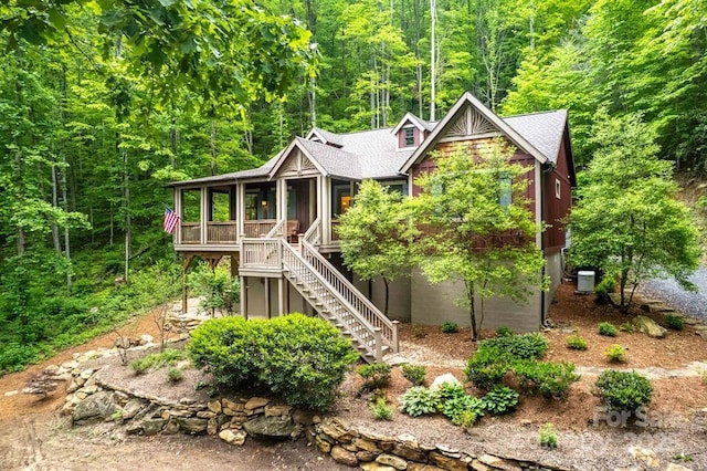 45 Boulder Creek Ln Unit 28, Tuckasegee, NC 28783 - chalet / cabin featuring stairway, a forest view, central AC, roof with shingles, and a sunroom