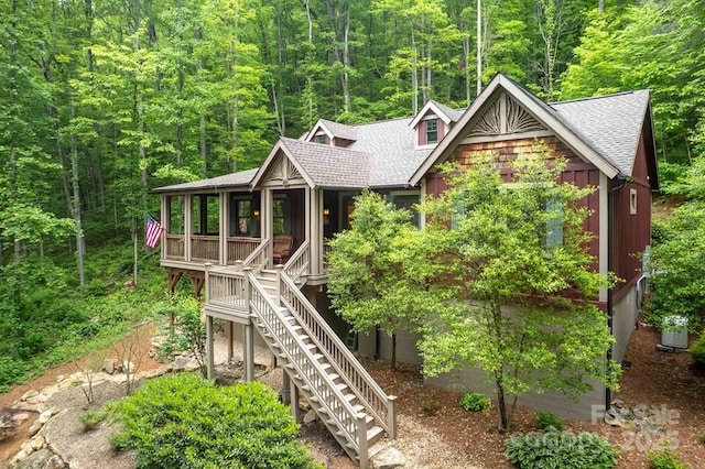 45 Boulder Creek Ln Unit 28, Tuckasegee, NC 28783 - view of front of home featuring a shingled roof, stairs, a wooded view, and a porch
