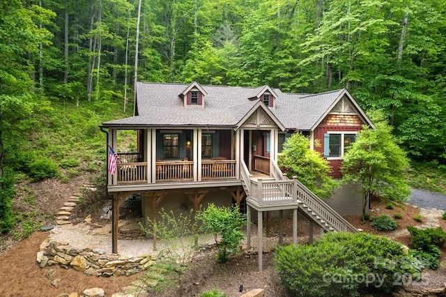 45 Boulder Creek Ln Unit 28, Tuckasegee, NC 28783 - rustic home with stairway, a view of trees, roof with shingles, and a porch