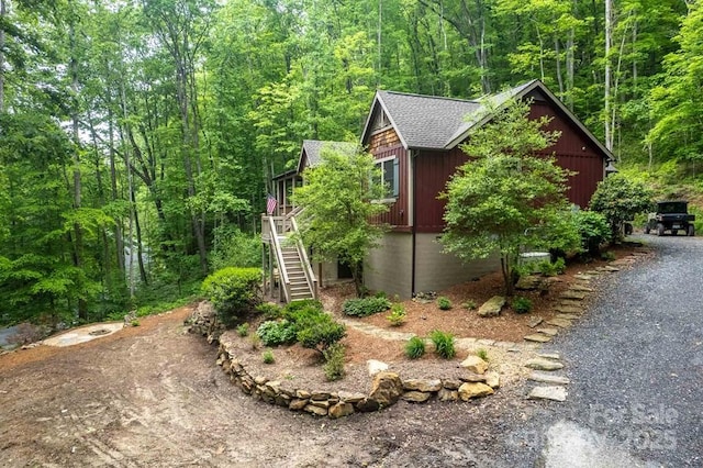 45 Boulder Creek Ln Unit 28, Tuckasegee, NC 28783 - view of side of property featuring stairs, a view of trees, and a shingled roof