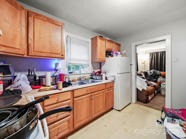 1004 E 8th Ave, Gastonia, NC 28054 - kitchen with a sink, light countertops, freestanding refrigerator, light floors, and brown cabinetry