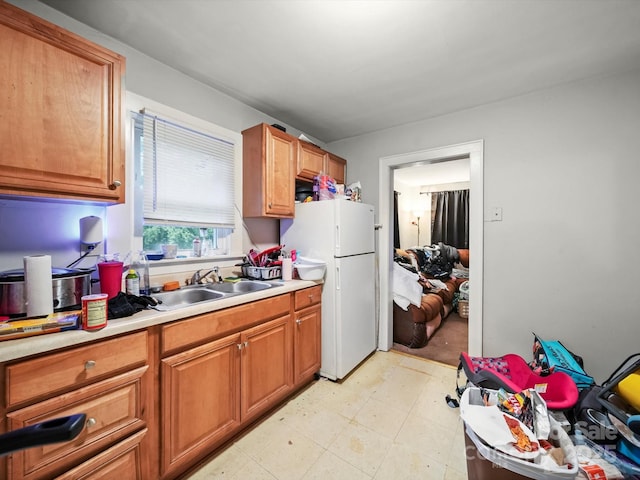 1004 E 8th Ave, Gastonia, NC 28054 - kitchen with a sink, freestanding refrigerator, light countertops, and brown cabinets