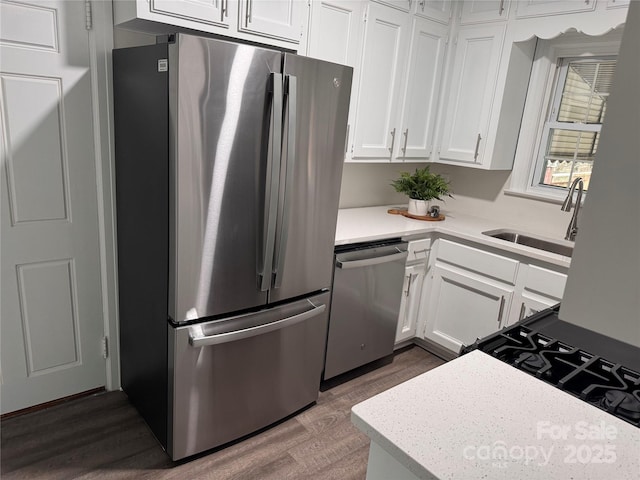 3726 The Plz, Charlotte, NC 28205 - kitchen featuring appliances with stainless steel finishes, a sink, dark wood-style flooring, white cabinetry, and light countertops
