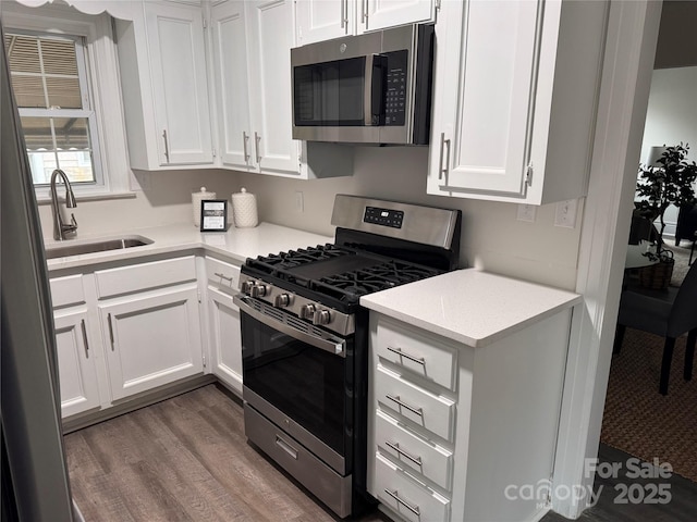 3726 The Plz, Charlotte, NC 28205 - kitchen with stainless steel appliances, a sink, white cabinetry, and dark wood-style floors