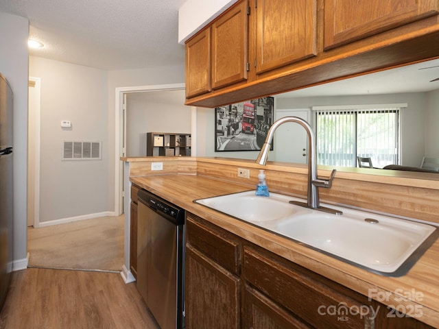 8208 Cedar Glen Dr, Charlotte, NC 28212 - kitchen with stainless steel dishwasher, a sink, light wood finished floors, wooden counters, and brown cabinets