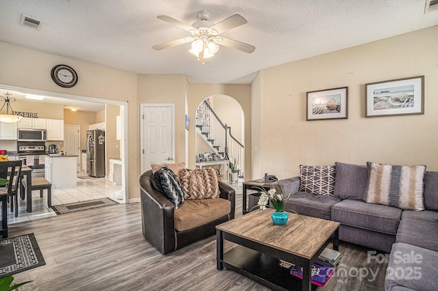 203 Alyssum Ct, Myrtle Beach, SC 29579 - living area with light wood-style floors, arched walkways, stairs, a ceiling fan, and a textured ceiling