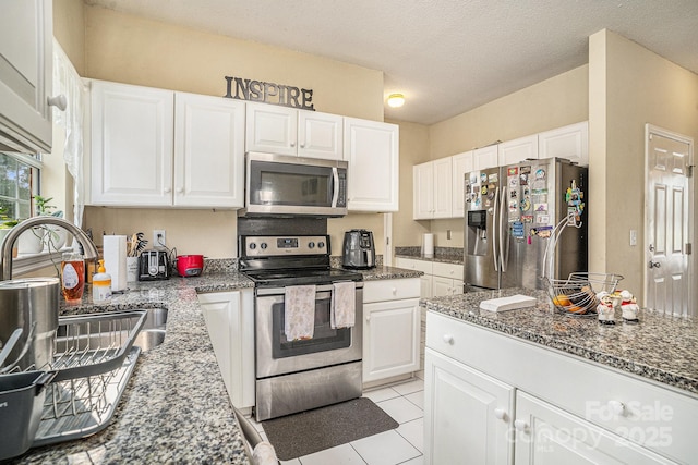 203 Alyssum Ct, Myrtle Beach, SC 29579 - kitchen featuring appliances with stainless steel finishes, a sink, white cabinetry, dark stone counters, and a textured ceiling
