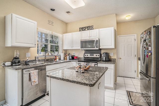 203 Alyssum Ct, Myrtle Beach, SC 29579 - kitchen featuring stainless steel appliances, a sink, white cabinets, light tile patterned floors, and a textured ceiling