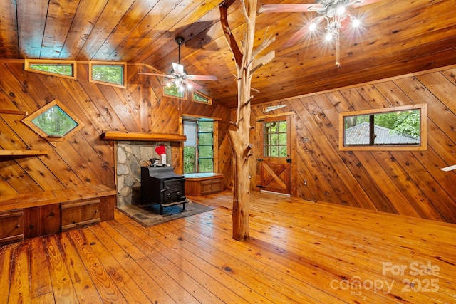 2951 Evergreen Trl, Vale, NC 28168 - living room featuring a ceiling fan, a wood stove, wooden walls, hardwood / wood-style floors, and wooden ceiling