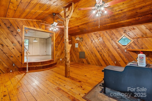 2951 Evergreen Trl, Vale, NC 28168 - bedroom featuring wood walls, hardwood / wood-style flooring, vaulted ceiling, wood ceiling, and a wood stove
