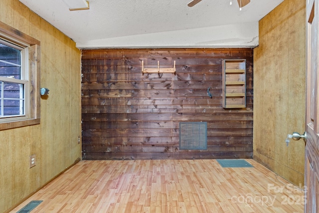2951 Evergreen Trl, Vale, NC 28168 - empty room with wood finished floors, ceiling fan, wood walls, and a textured ceiling