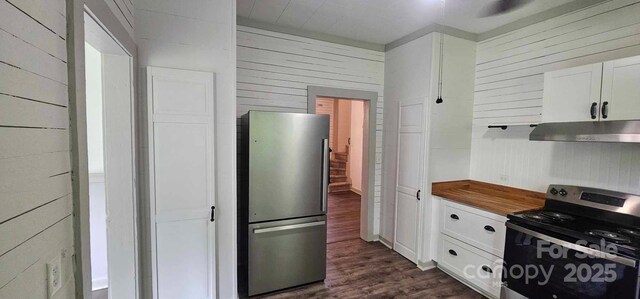 804 N Main St, Oakboro, NC 28129 - kitchen with freestanding refrigerator, range with electric cooktop, wood walls, dark wood-style flooring, and white cabinetry