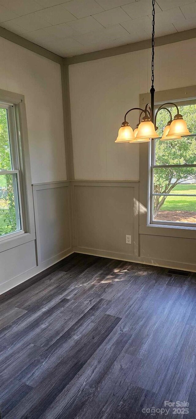 804 N Main St, Oakboro, NC 28129 - unfurnished room featuring dark wood-style flooring, a decorative wall, and a chandelier