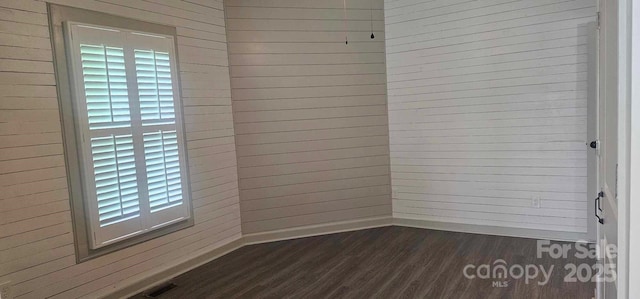 804 N Main St, Oakboro, NC 28129 - unfurnished room featuring dark wood-type flooring, baseboards, and wooden walls
