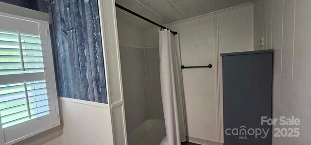 804 N Main St, Oakboro, NC 28129 - bathroom with healthy amount of natural light, wainscoting, crown molding, a decorative wall, and shower / bath combo with shower curtain