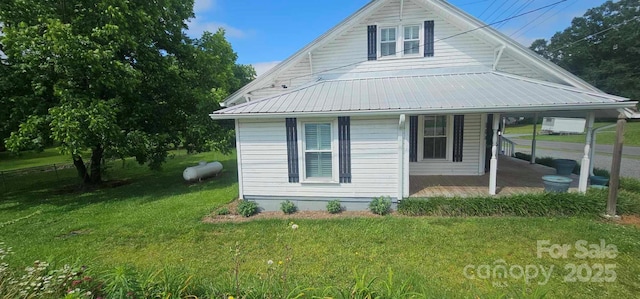 804 N Main St, Oakboro, NC 28129 - view of home's exterior with a porch, a lawn, and metal roof