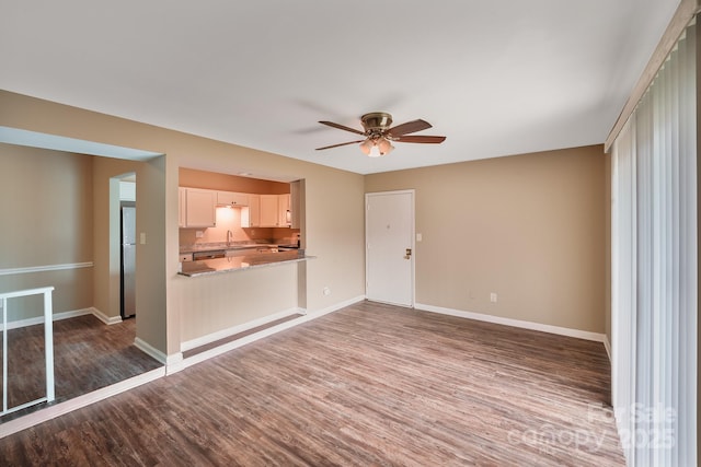 809 High Meadow Ln Unit F, Charlotte, NC 28217 - unfurnished living room with a sink, wood finished floors, a ceiling fan, and baseboards