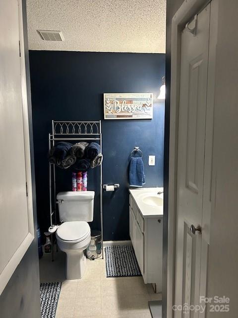 114 Wayne Ave, Kannapolis, NC 28081 - bathroom featuring vanity, toilet, and a textured ceiling