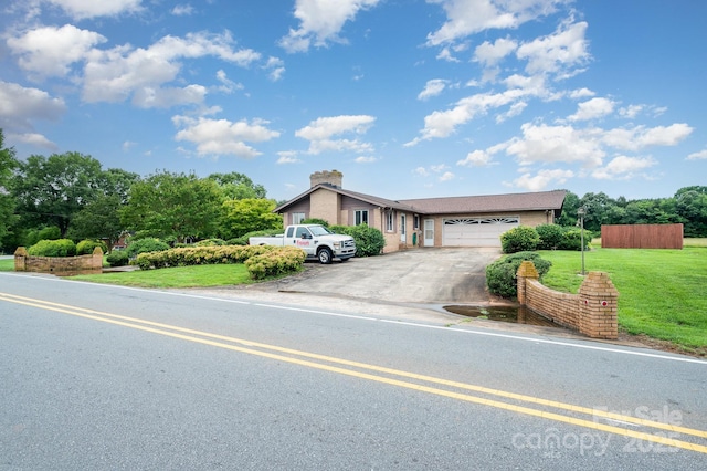 1410 Patterson St, China Grove, NC 28023 - view of front facade with an attached garage, driveway, a front lawn, and a chimney