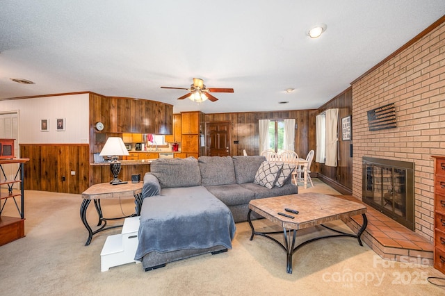 1410 Patterson St, China Grove, NC 28023 - living area with wood walls, a ceiling fan, light colored carpet, a fireplace, and ornamental molding