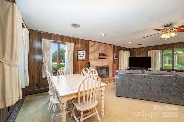 1410 Patterson St, China Grove, NC 28023 - dining room featuring wood walls, carpet flooring, a fireplace, and ceiling fan