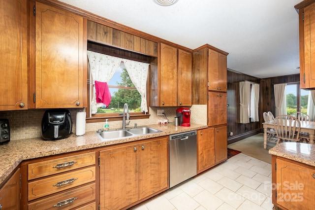 1410 Patterson St, China Grove, NC 28023 - kitchen with stainless steel dishwasher, tasteful backsplash, brown cabinets, wooden walls, and crown molding