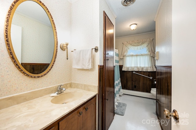 1410 Patterson St, China Grove, NC 28023 - bathroom with a baseboard radiator, ornamental molding, vanity, wallpapered walls, and a wainscoted wall