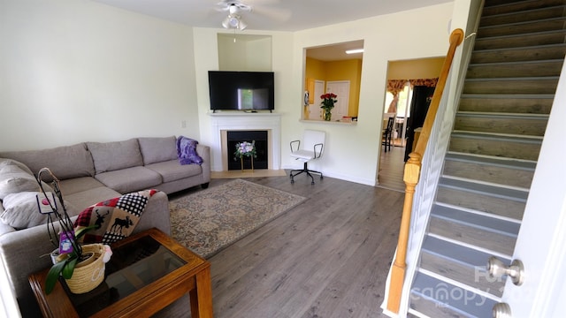 7046 Dorn Cir, Charlotte, NC 28212 - living area with stairway, wood finished floors, a fireplace, a ceiling fan, and baseboards
