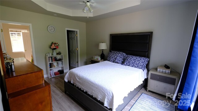 7046 Dorn Cir, Charlotte, NC 28212 - bedroom featuring wood finished floors, a raised ceiling, baseboards, and a ceiling fan