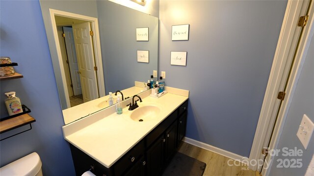 7046 Dorn Cir, Charlotte, NC 28212 - half bath featuring wood finished floors, vanity, toilet, and baseboards