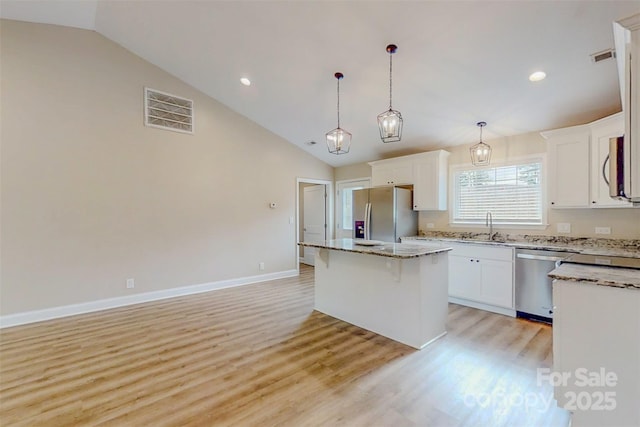 108 Devynne Ct, Salisbury, NC 28146 - kitchen with appliances with stainless steel finishes, a sink, lofted ceiling, a center island, and light wood-type flooring
