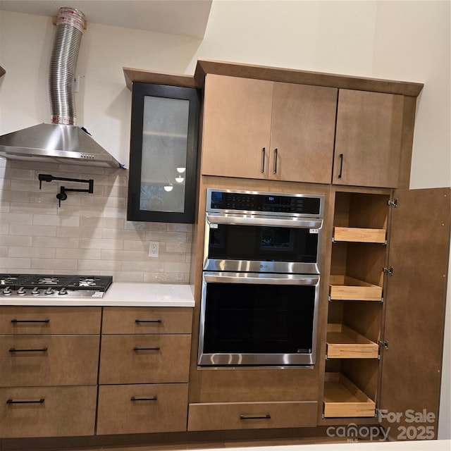 30 Sand Hill Rd, Asheville, NC 28806 - kitchen with wall chimney exhaust hood, appliances with stainless steel finishes, tasteful backsplash, glass insert cabinets, and light countertops