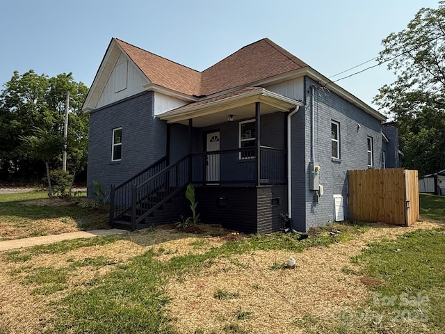 506 N Styers St, Cherryville, NC 28021 - view of front facade featuring brick siding, a front lawn, covered porch, and roof with shingles