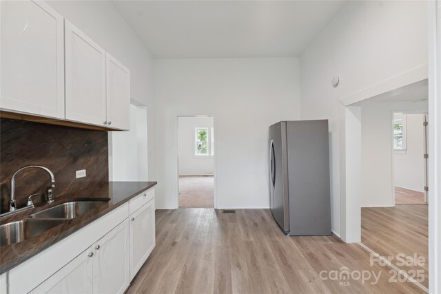 506 N Styers St, Cherryville, NC 28021 - kitchen with freestanding refrigerator, a sink, white cabinets, and light wood finished floors