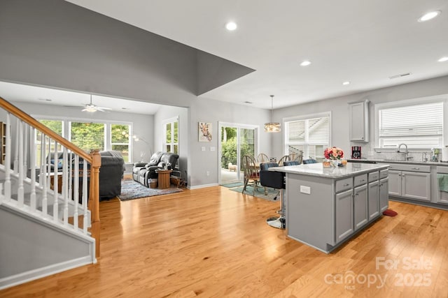 219 Broadleaf Dr, Denver, NC 28037 - kitchen with gray cabinetry, a kitchen island, light wood-style floors, recessed lighting, and hanging light fixtures