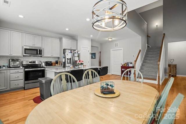 219 Broadleaf Dr, Denver, NC 28037 - dining room featuring stairs, light wood-style floors, a chandelier, and recessed lighting